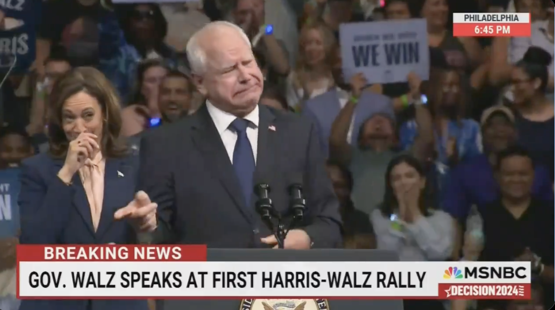 Gov. Walz speaks at First Harris-Walz Rally in Philadelphia. Kamala Harris stands beside him smiling, while supporters hold signs in the background. MSNBC 6:45 PM