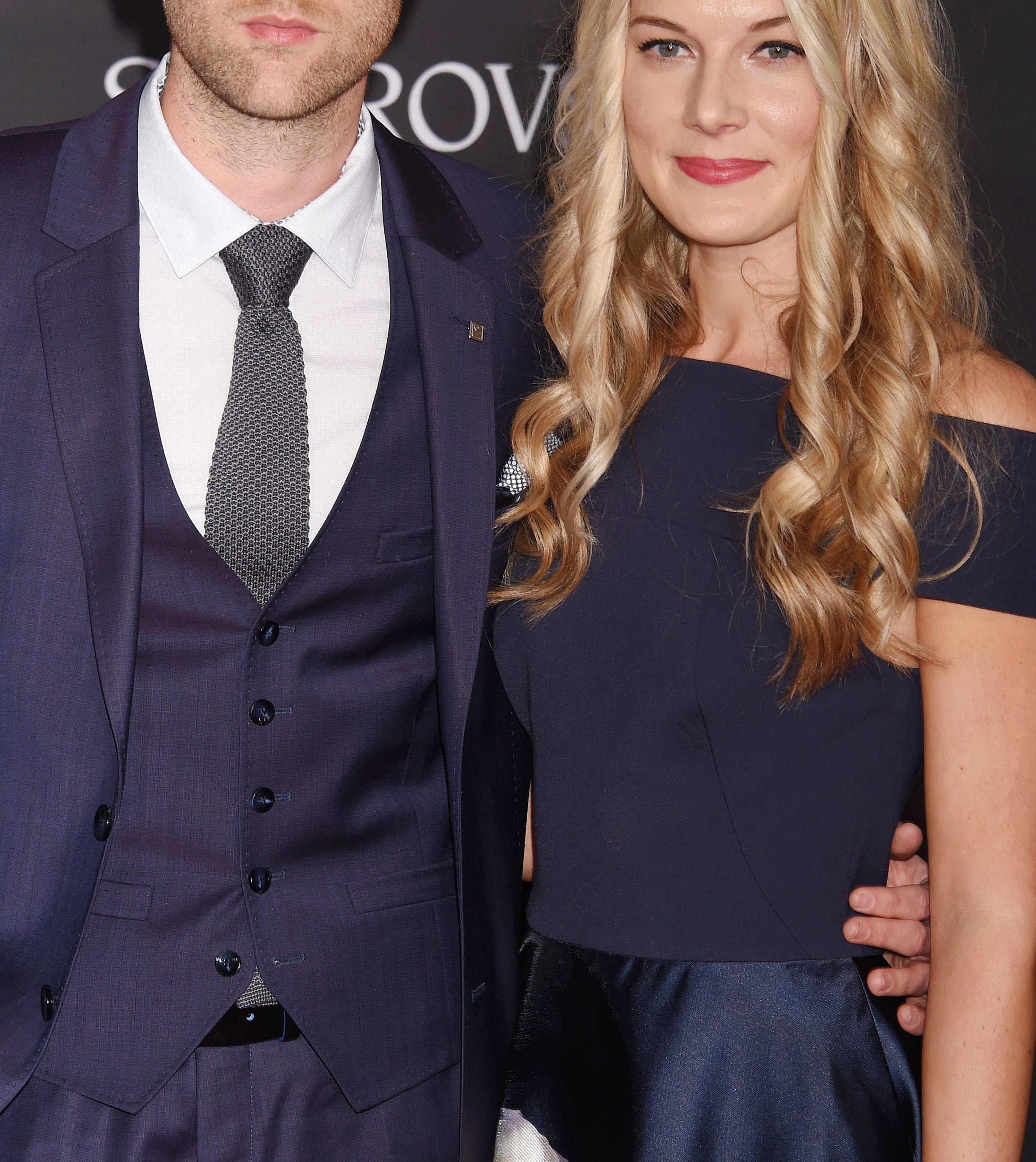 Matthew Lewis and Angela Jones at a Beauty and the Beast event. Matthew is in a dark suit and tie, while Angela wears an off-the-shoulder floral dress