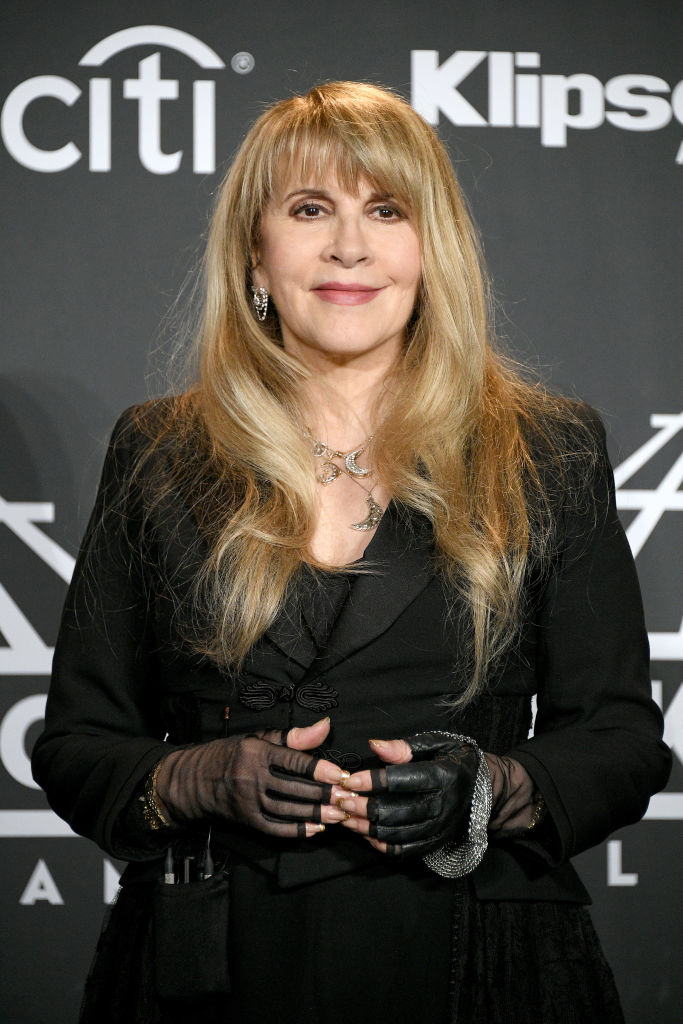 Stevie Nicks in a black outfit with sheer gloves