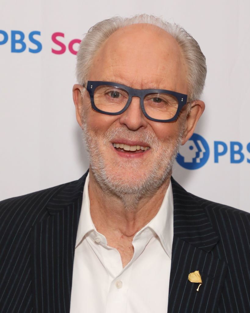 John Lithgow in a pinstriped suit and white shirt at a PBS event