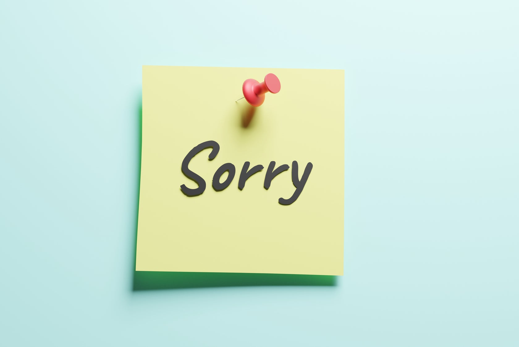 A sticky note pinned to a board reads "Sorry" in black handwriting