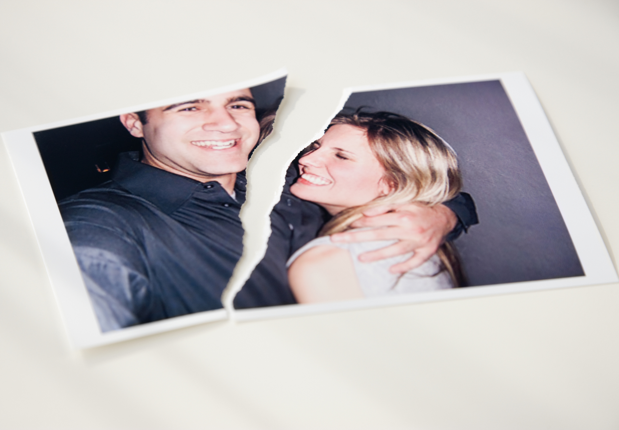 A torn photograph of a smiling couple embracing