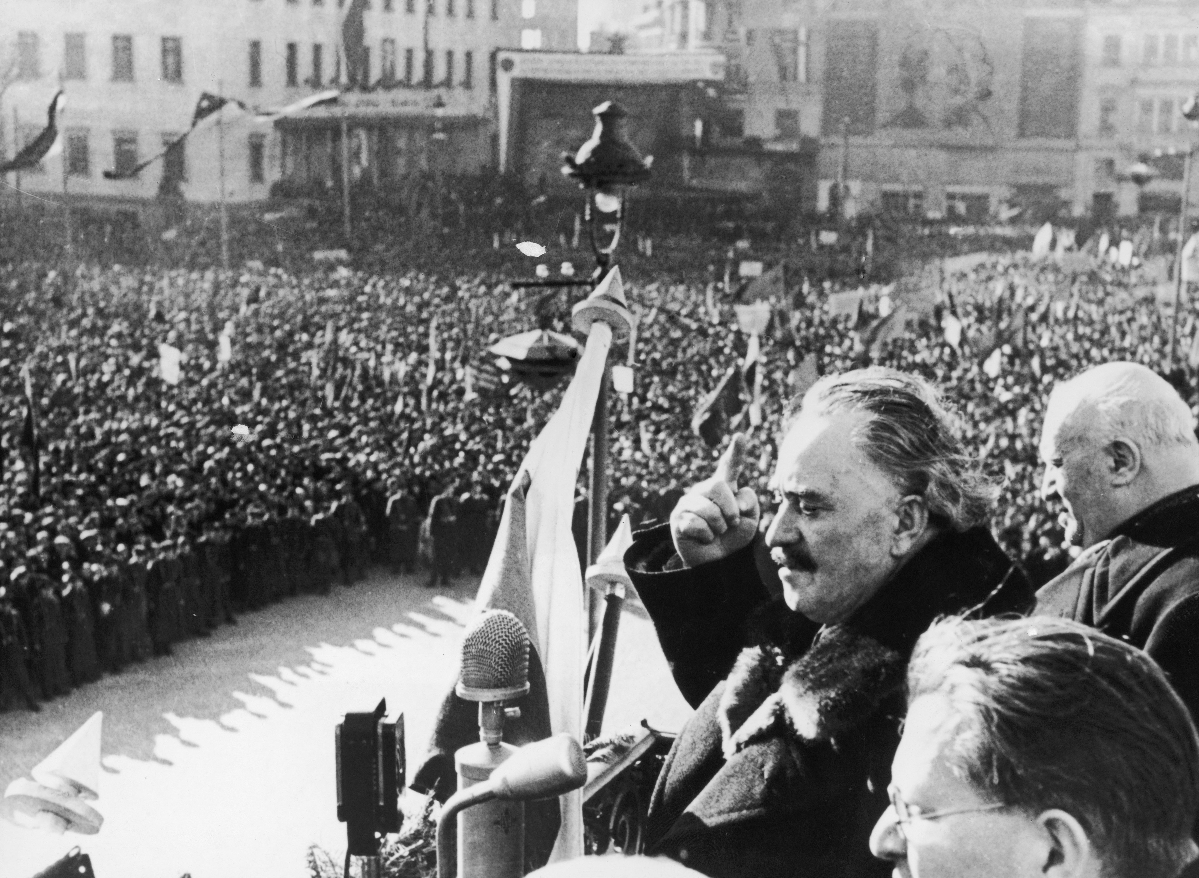 A massive crowd from a balcony, the scene is filled with people and flags in the background from Bulgaria 1948