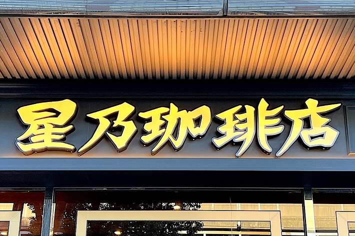 The image shows a storefront with Japanese kanji characters on the sign above the entrance