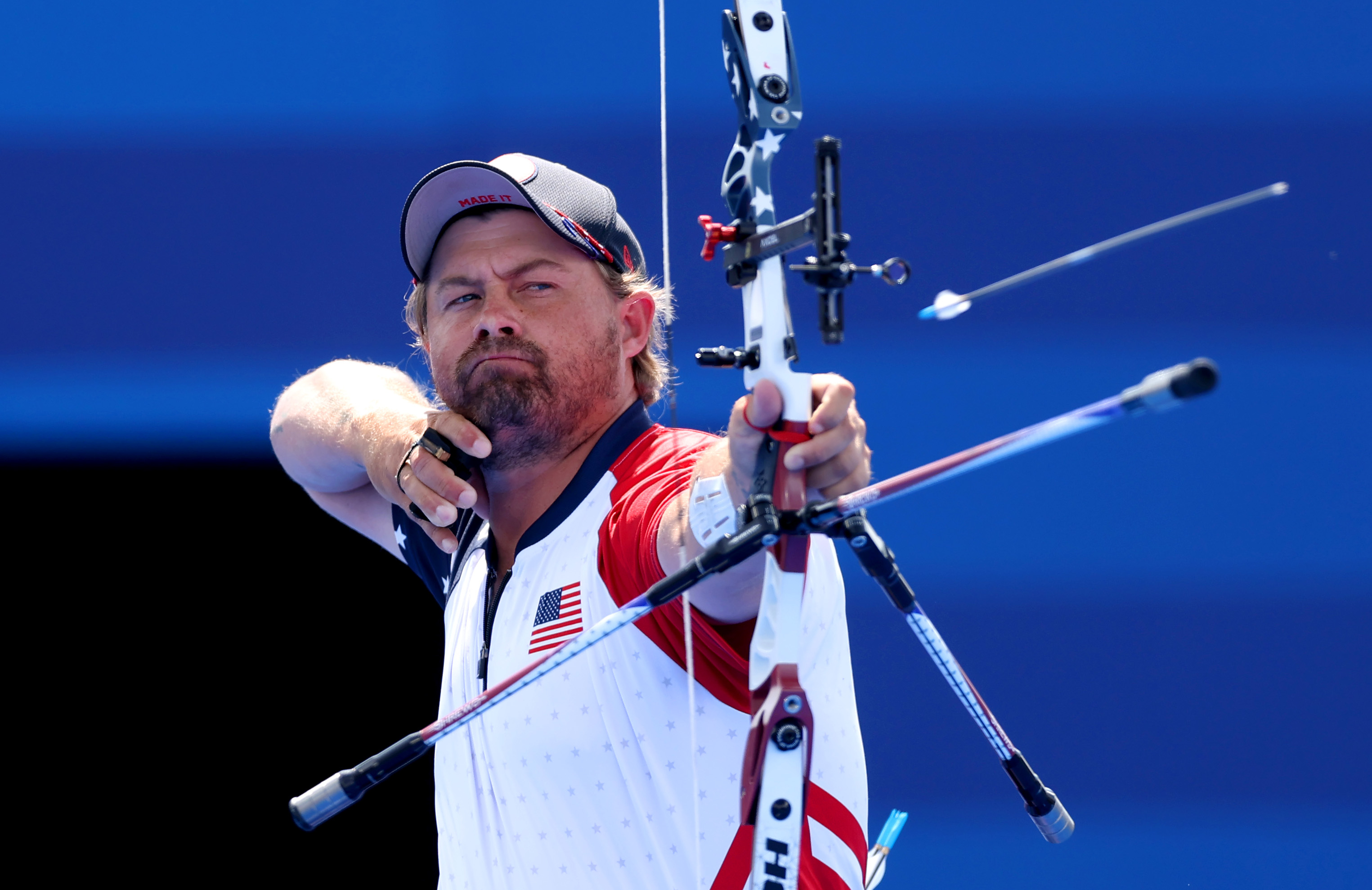 Matt Stutzman, an archer wearing a U.S. team uniform, aims his bow during a competition