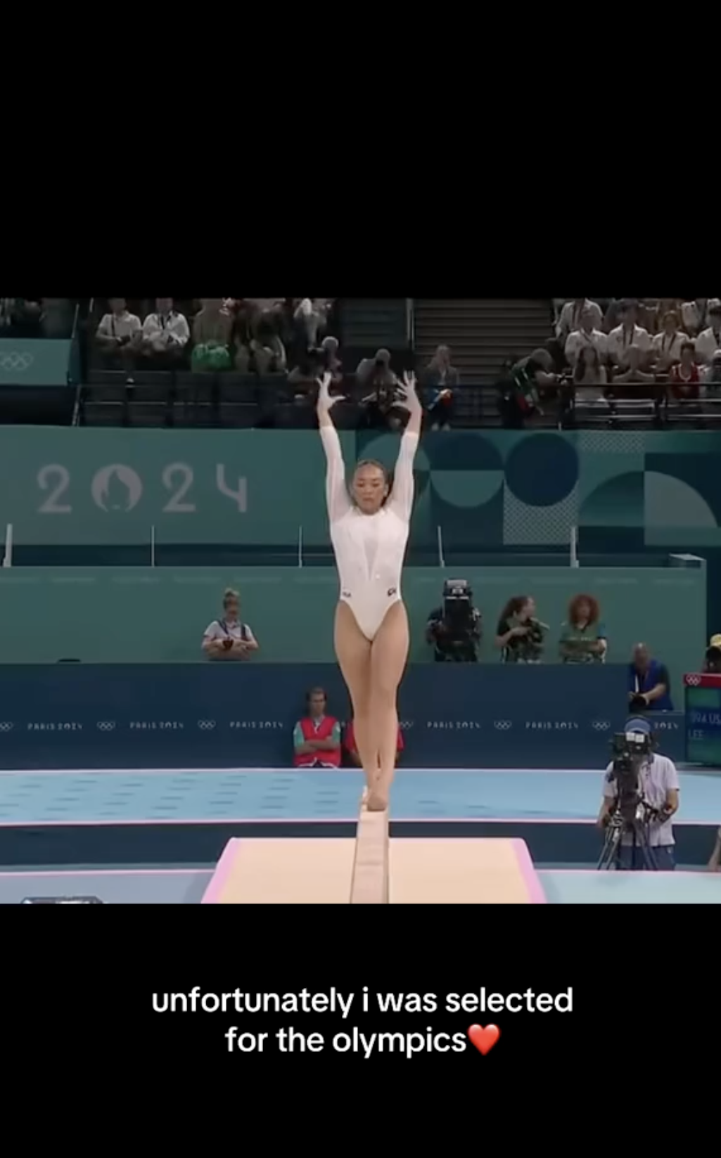 Gymnast performs on balance beam at the Paris 2024 Olympic Games. Text below image reads: "unfortunately i was selected for the olympics❤️"