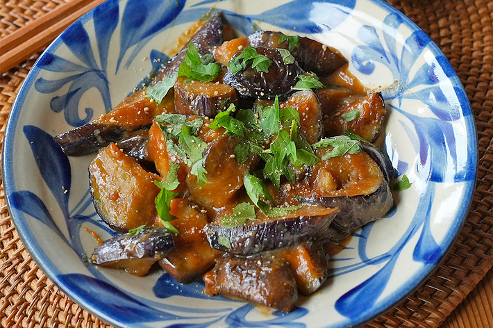 皿に盛り付けられたナスの料理と白ご飯の小鉢。