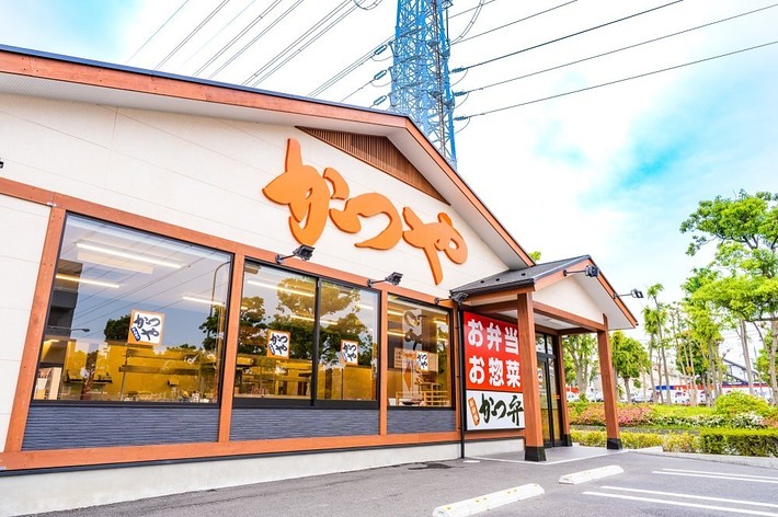 かつやの店舗外観。大きな「かつや」の看板と「お弁当、お惣菜」の表示。