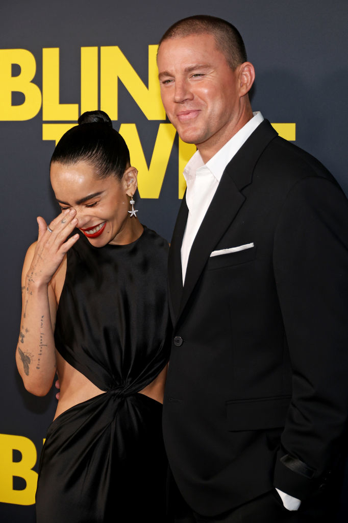 Zoe Kravitz and Channing Tatum standing together on a red carpet. Zoe is wearing a stylish cut-out black gown, while Channing is in a black suit with a white shirt
