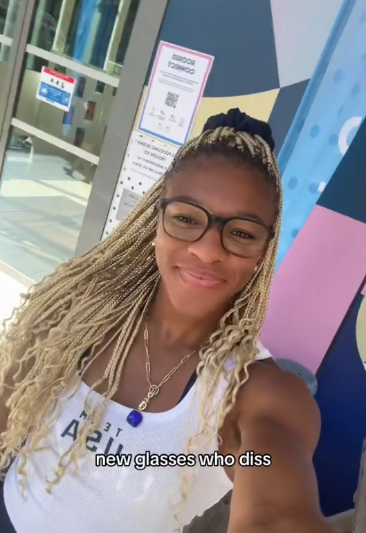 Ariana Ramsey smiles in front of a building, showing off her new glasses. Text on the image reads: &quot;new glasses who diss&quot;