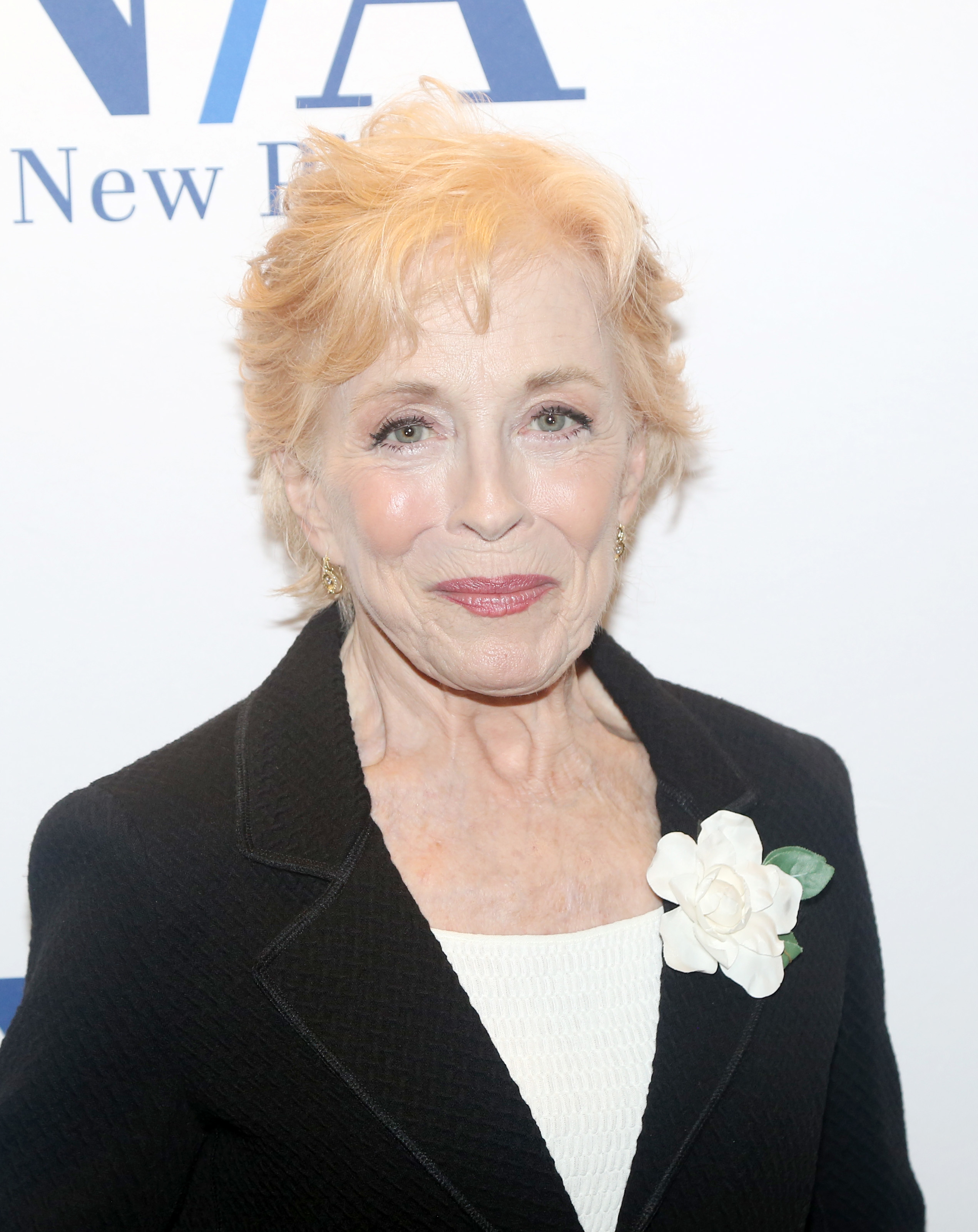 Holland Taylor attends an event, wearing a blazer with a flower pinned to it and a top underneath