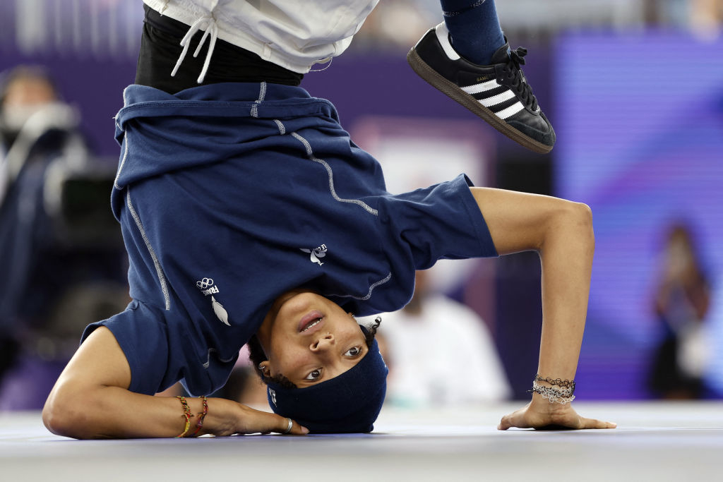 Olympic breakdancer B-Girl Syssy performs a headstand during a dance competition