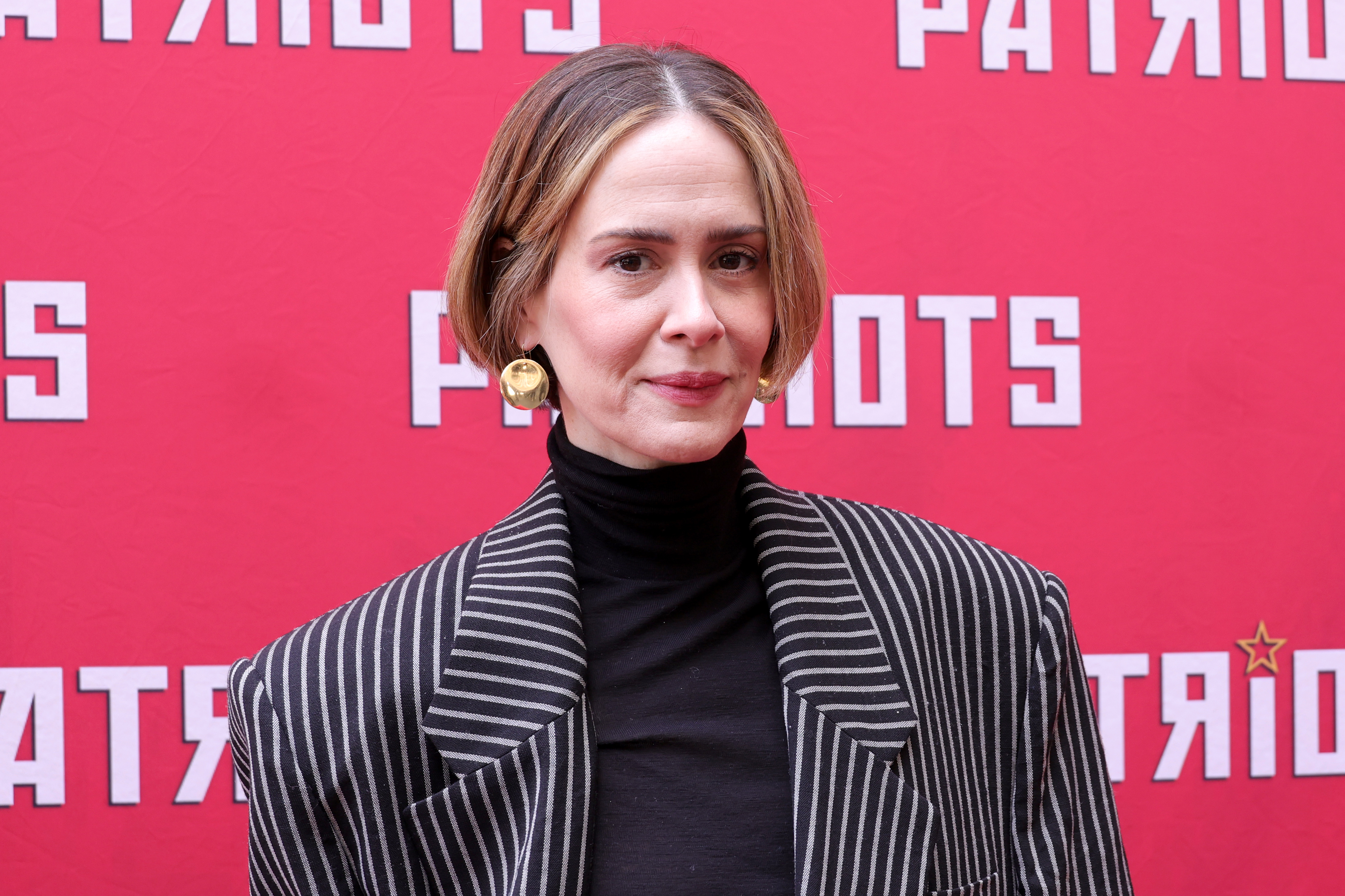 Sarah Paulson in a turtleneck and a pinstripe blazer at the "Patriots" event backdrop