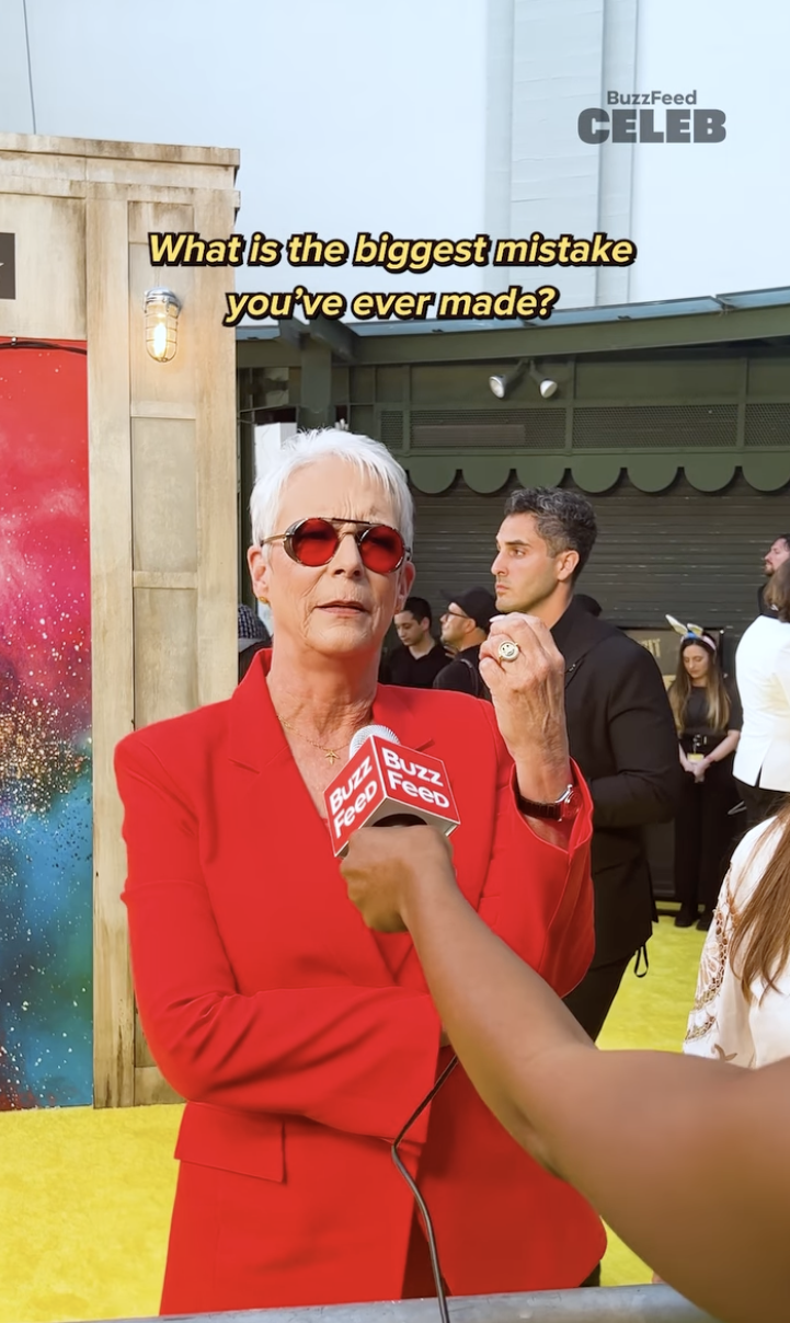 Jamie Lee Curtis speaks to BuzzFeed Celeb on a yellow carpet. Text above her reads, "What is the biggest mistake you've ever made?"