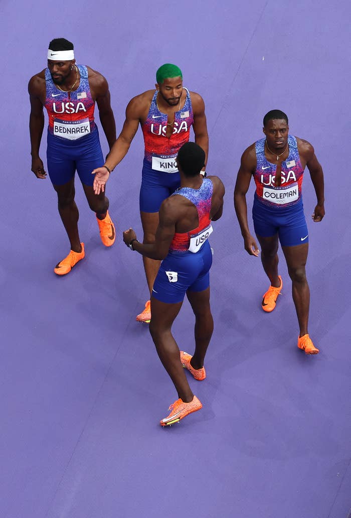 Sprinters Kenny Bednarek, Tre King, Fred Kerley, and Christian Coleman of USA in track uniforms during a relay race at a sporting event