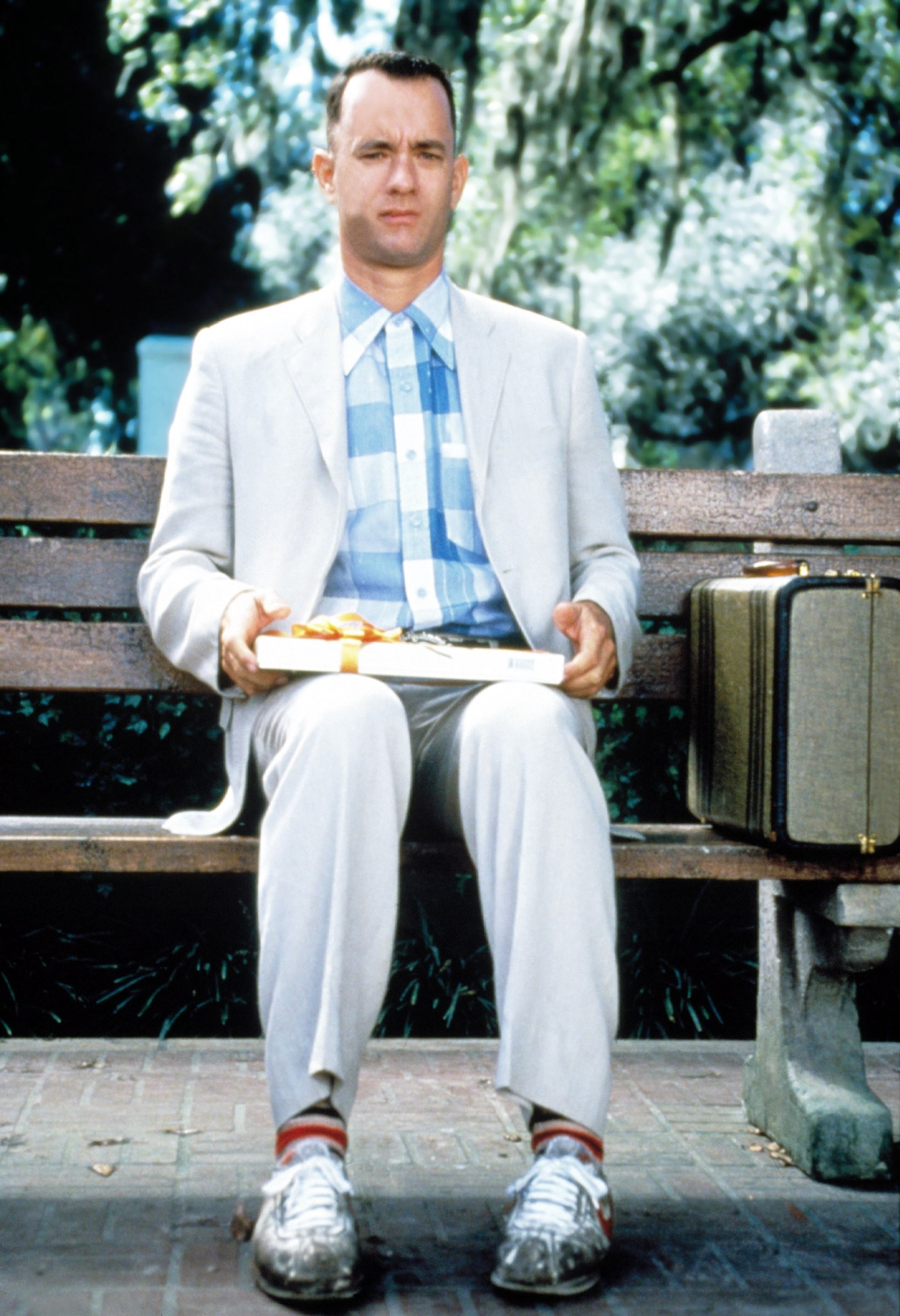 Tom Hanks sitting on a bench with a box of chocolates in a scene from "Forrest Gump"