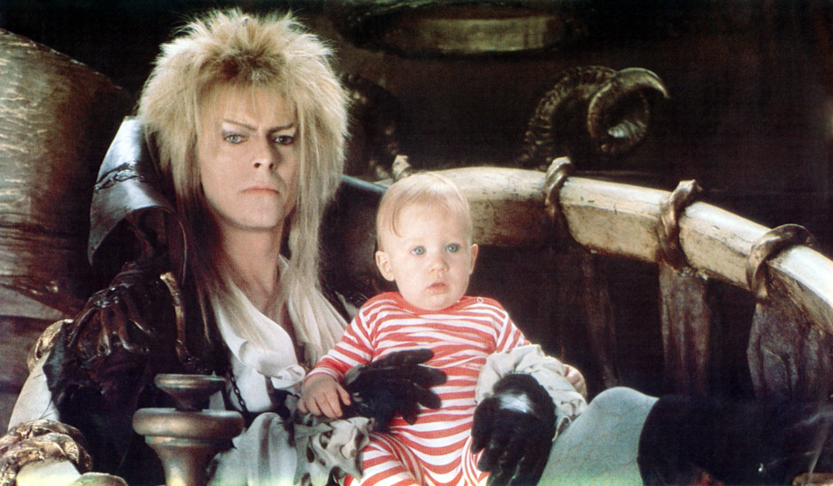 David Bowie holding a baby in a scene from "Labyrinth"