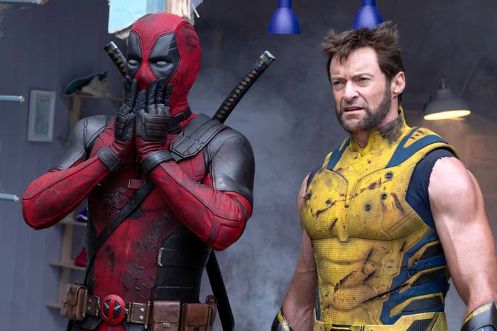 Ryan Reynolds as Deadpool, in a red and black armored suit, and Hugh Jackman as Wolverine, in a yellow and black combat suit, appear surprised