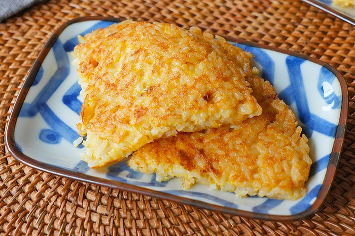 お皿に盛られた2切れの焼きおにぎりがテーブルに置かれている。