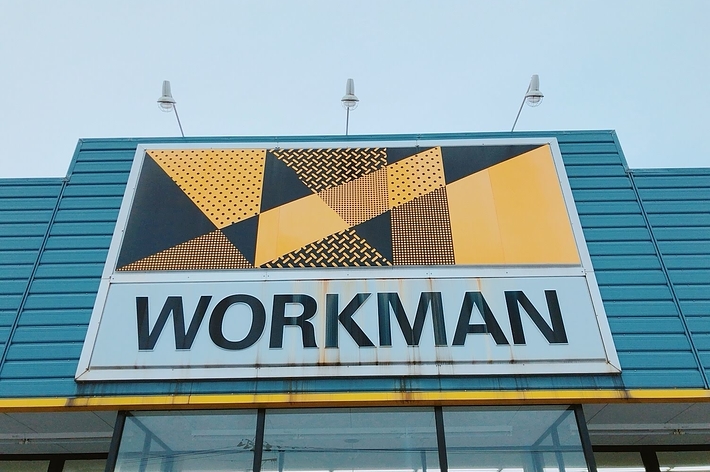 Storefront with the name &ldquo;WORKMAN&rdquo; displayed on a sign with geometric patterns above
