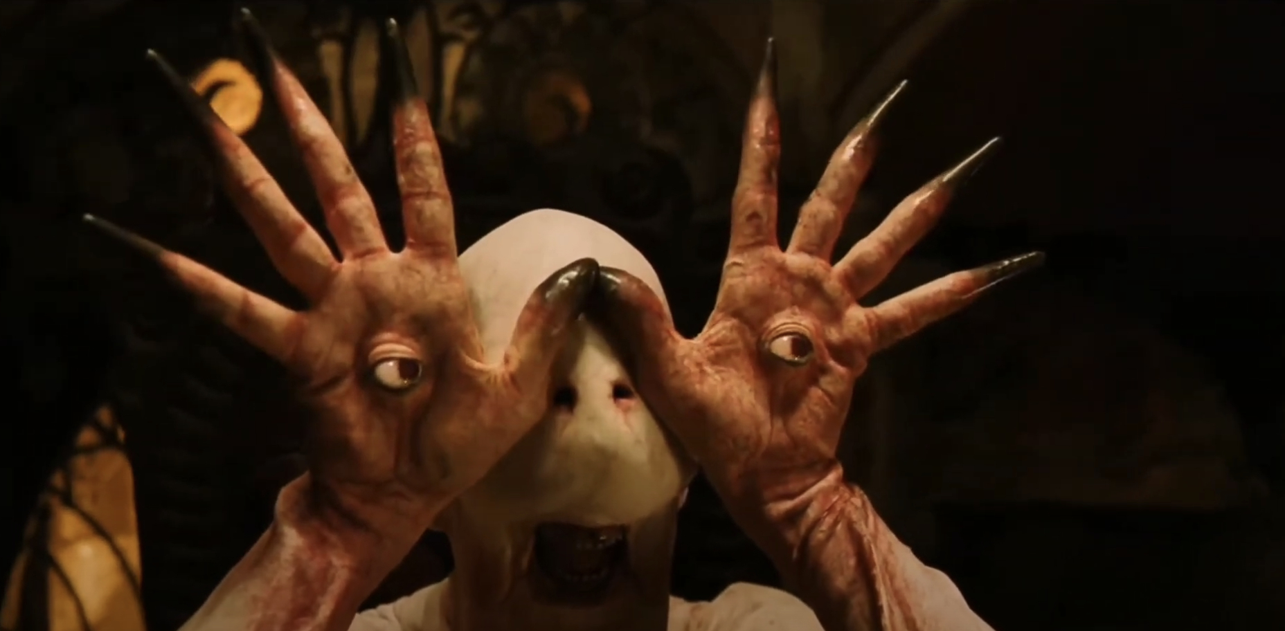 The Pale Man character from &quot;Pan's Labyrinth&quot; holding his hands in front of his face, each with an eyeball in the palm