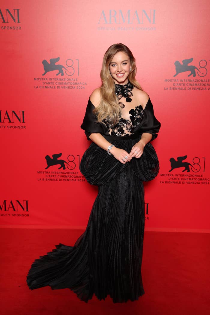 Sydney Sweeney on the red carpet in an elegant gown with floral accents at the Venice International Film Festival 2024