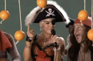 Pink dressed as a pirate, singing with backup dancers in pirate costumes