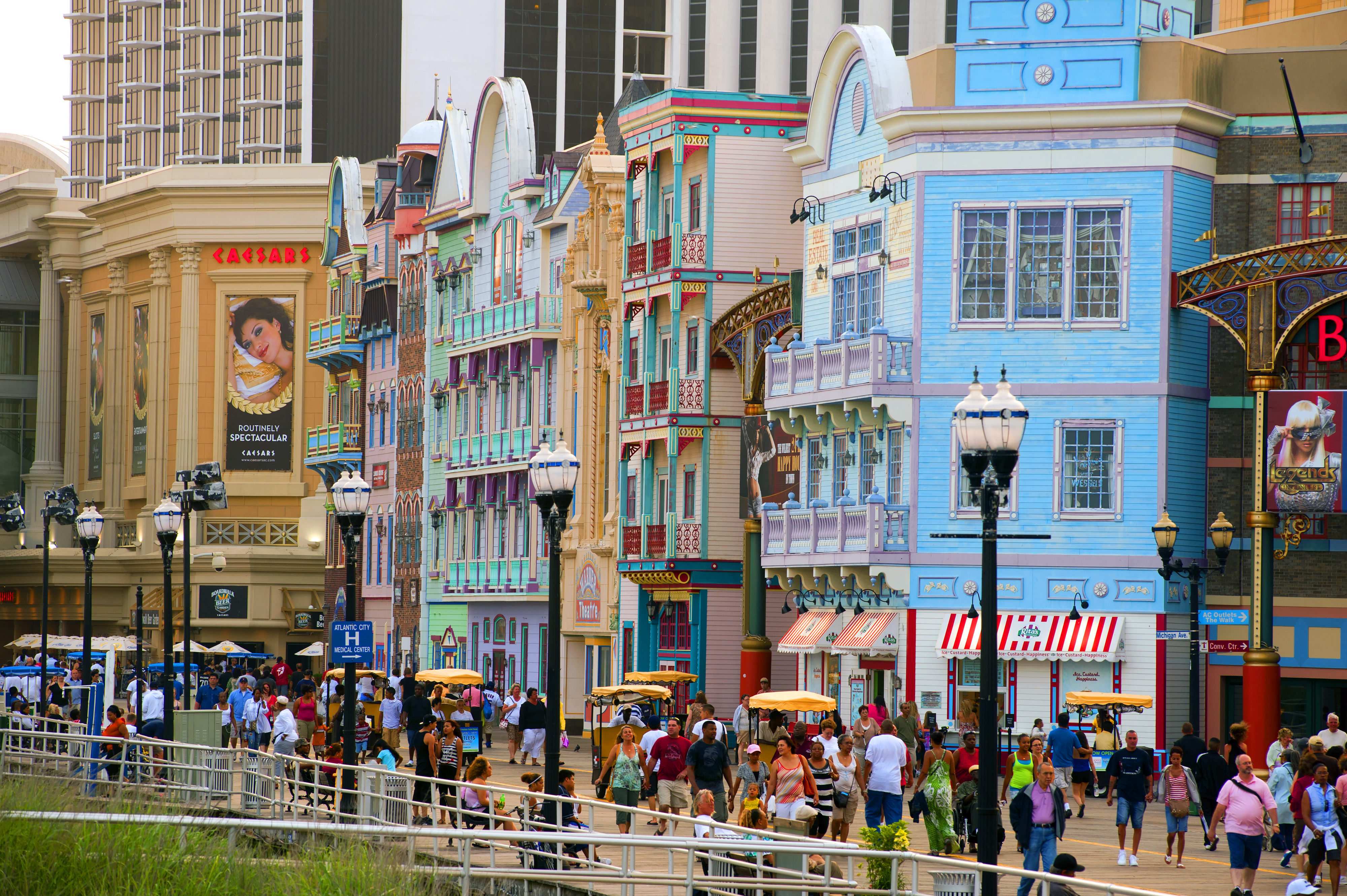 A bustling street in Atlantic City with colorful buildings and crowds of people enjoying an outdoor promenade