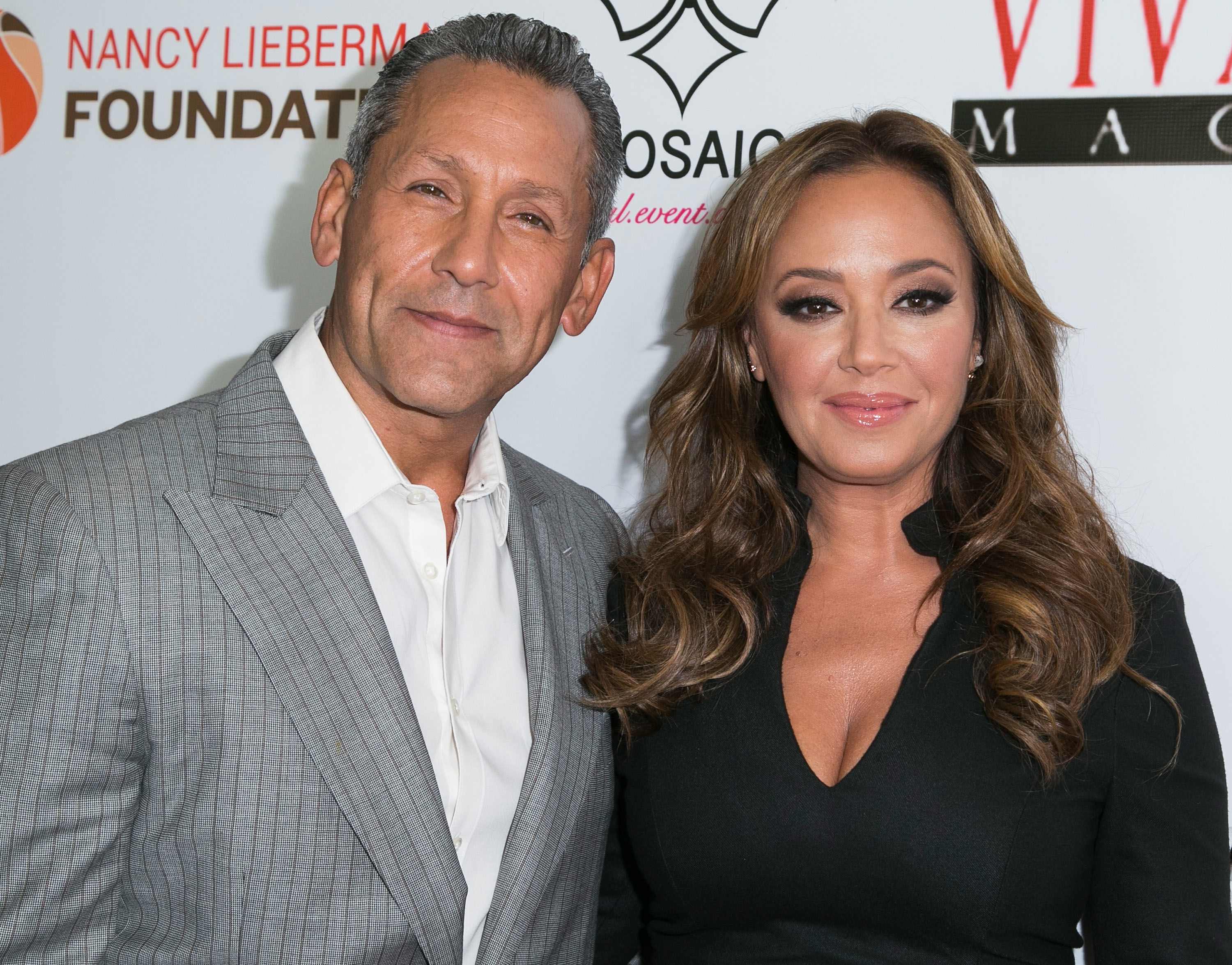 George R. and Leah R. pose together on the red carpet, with both dressed in formal attire