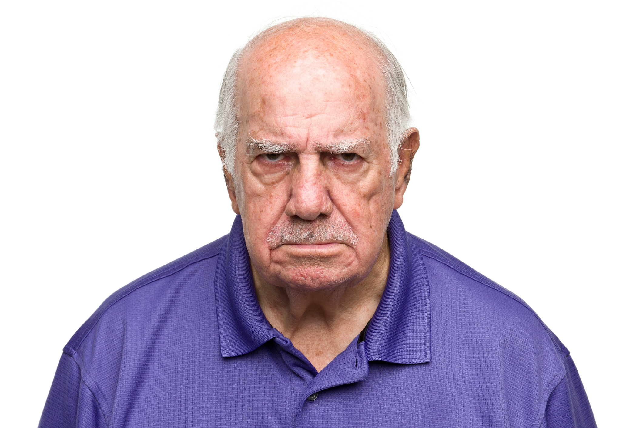 Older man wearing a polo shirt has an angry facial expression, looking directly into the camera