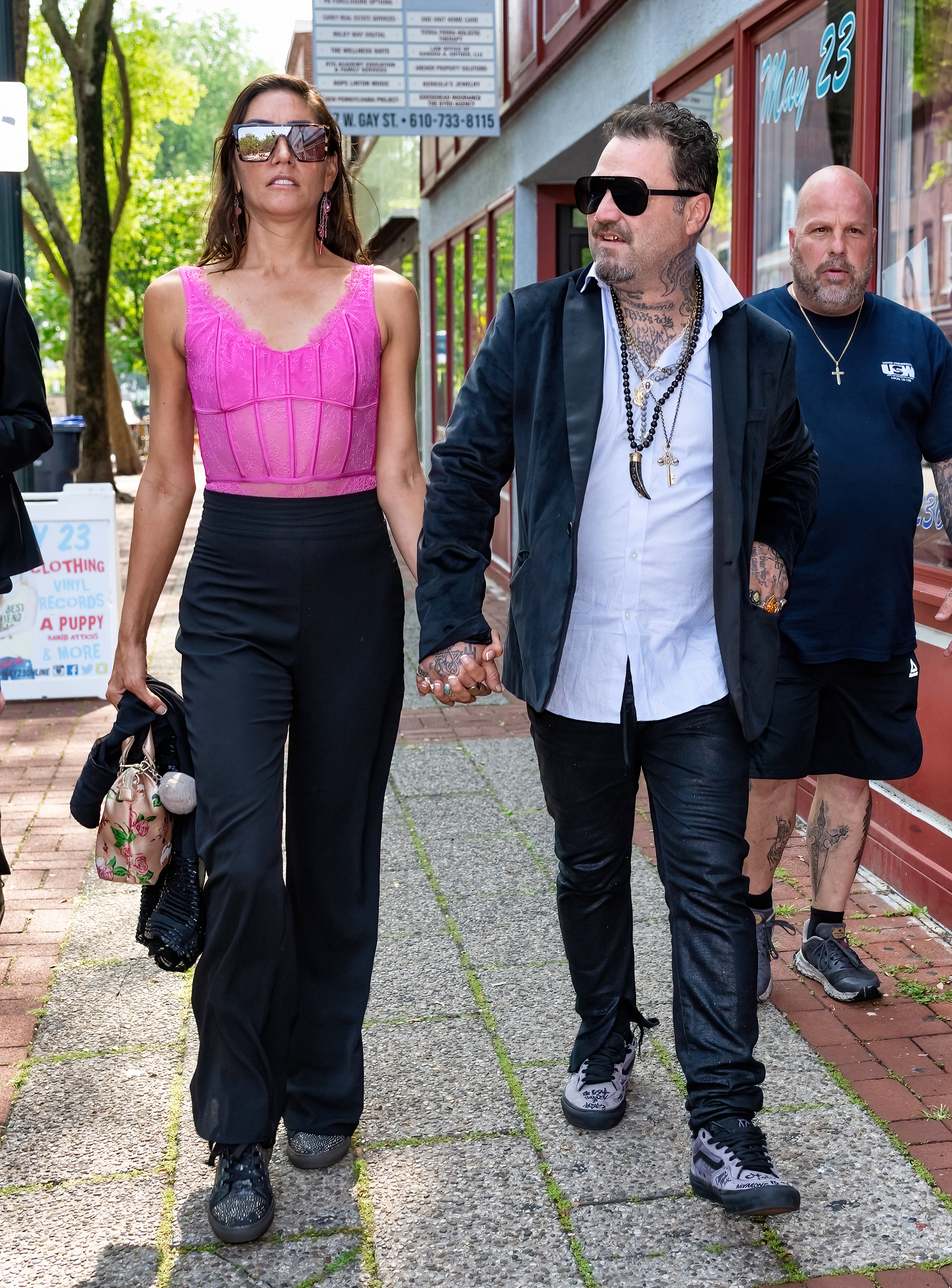 Bam Margera and Nicole Boyd hold hands while walking on a city street