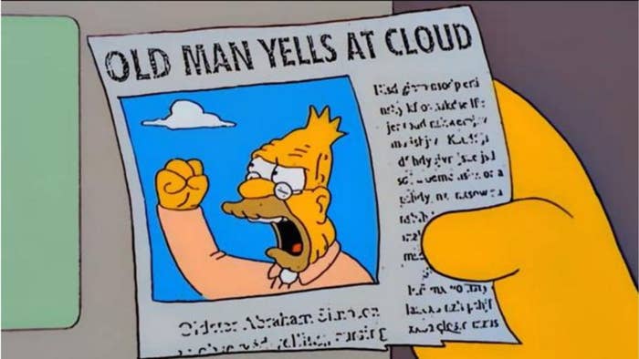 A hand holds a newspaper with a headline "Old Man Yells at Cloud" above an image of Grandpa Simpson angrily shaking his fist at the sky