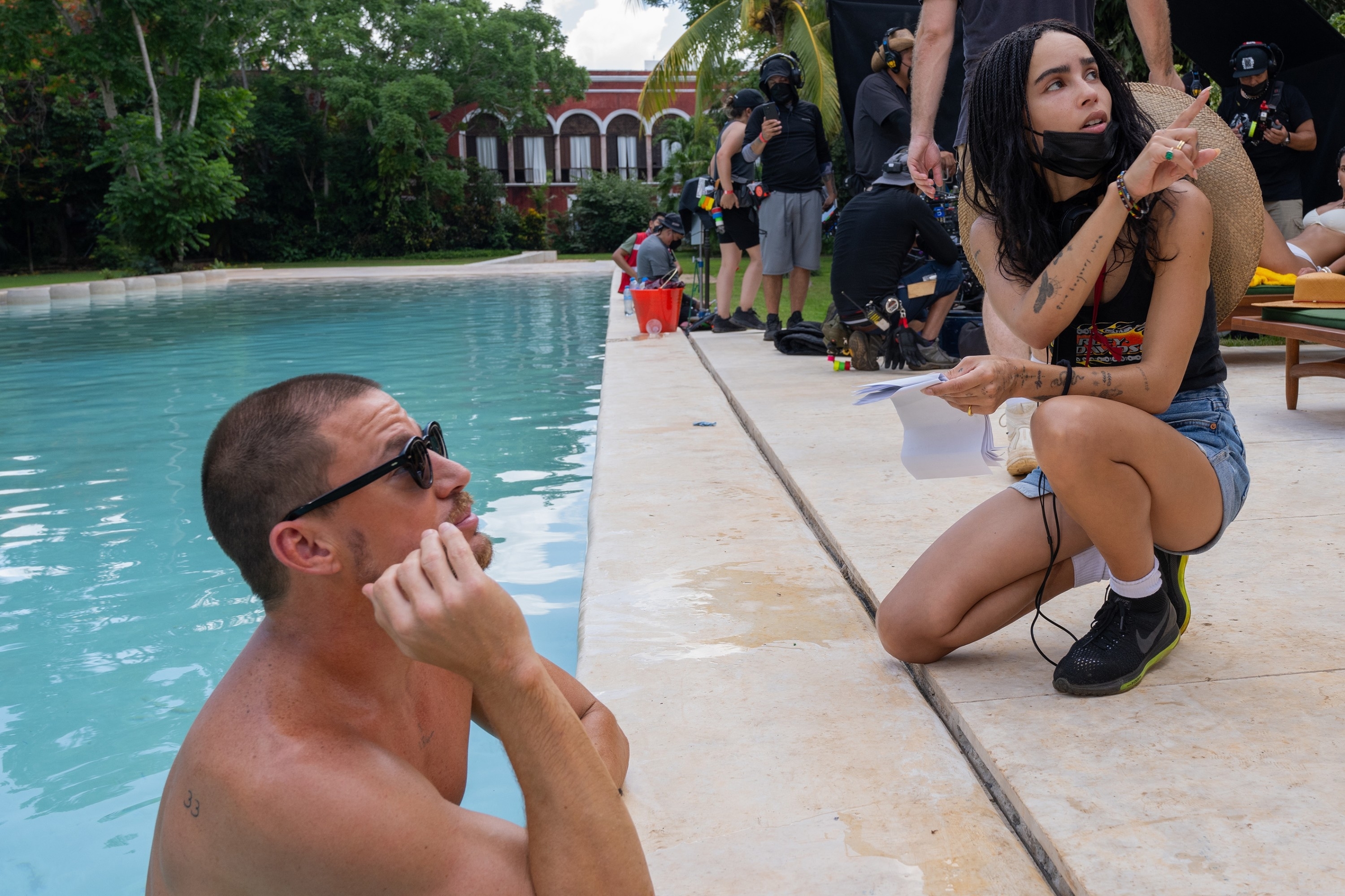Channing in a pool and Zoë Kravitz wearing casual clothes as they work on set