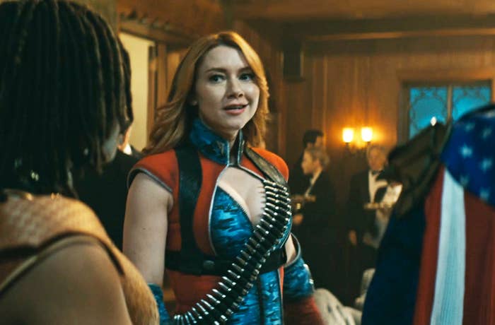 Valorie Curry in a superhero outfit with a bullet chain across her chest in a formal gathering, surrounded by people in evening wear