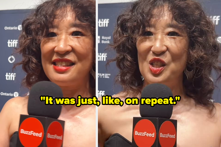 Sandra Oh speaking at a BuzzFeed interview on a TIFF red carpet event, wearing an elegant off-shoulder outfit