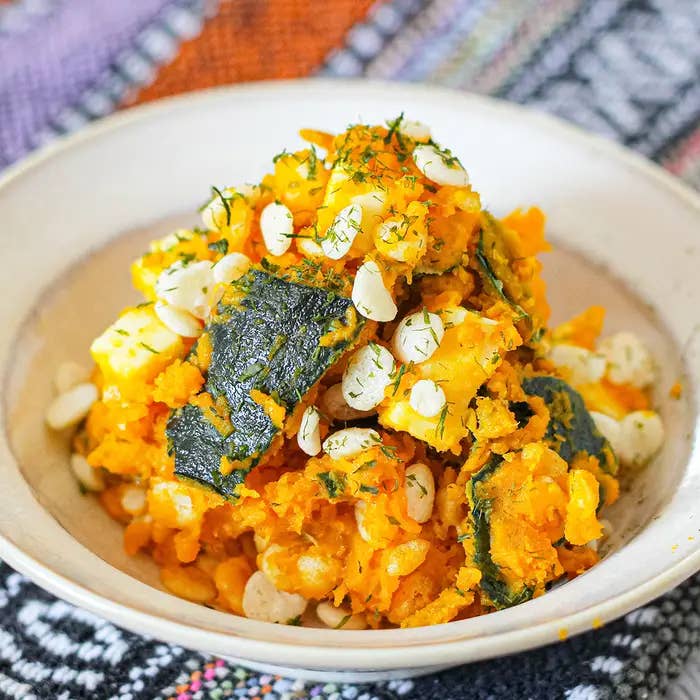 白い皿に盛られたかぼちゃとコーンの料理。