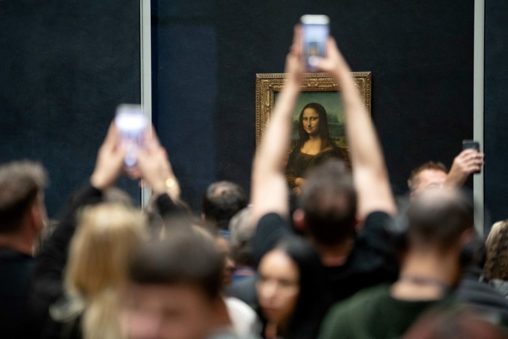 A crowd of museum visitors take photos of Leonardo da Vinci's painting &quot;Mona Lisa&quot; displayed in the Louvre Museum
