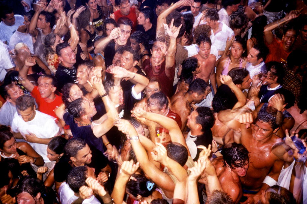 A large crowd of people energetically dancing and celebrating at what appears to be a lively party scene