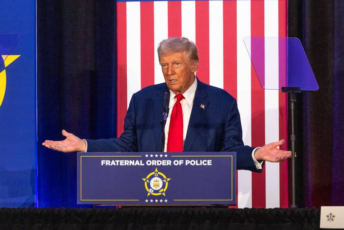 Donald Trump speaks at a podium labeled "Fraternal Order of Police." A U.S. flag is partially visible in the background