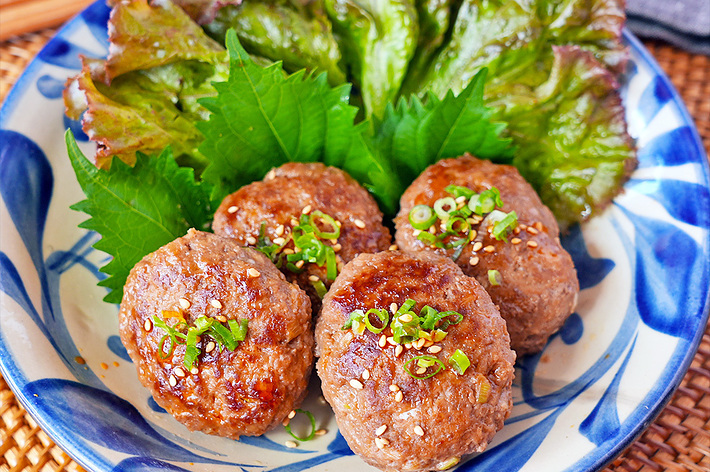 皿に盛られた肉団子4個、手前に青じそとレタスが添えられています。