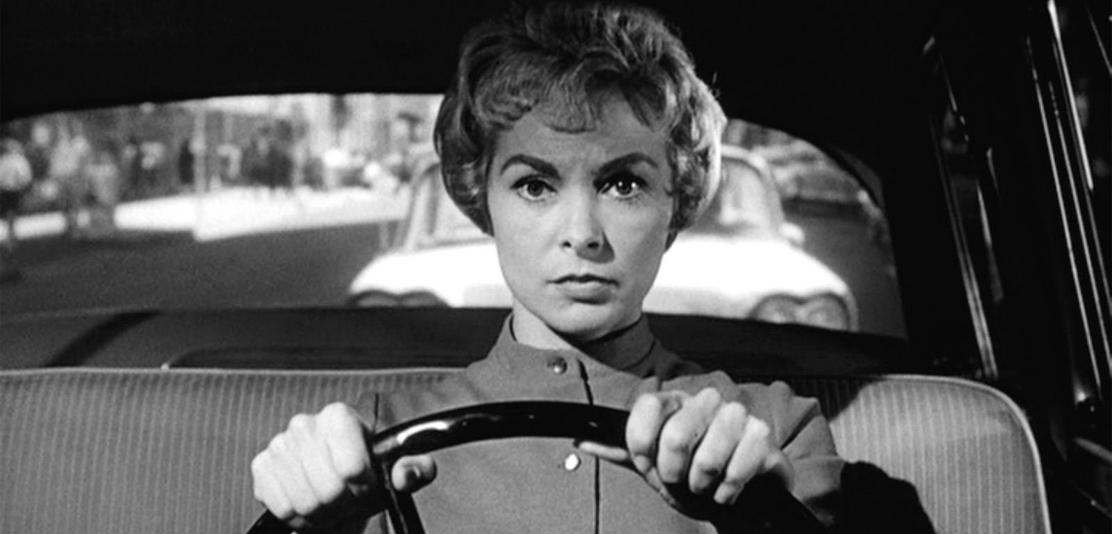 Janet Leigh in a black-and-white scene, driving a car with a focused expression