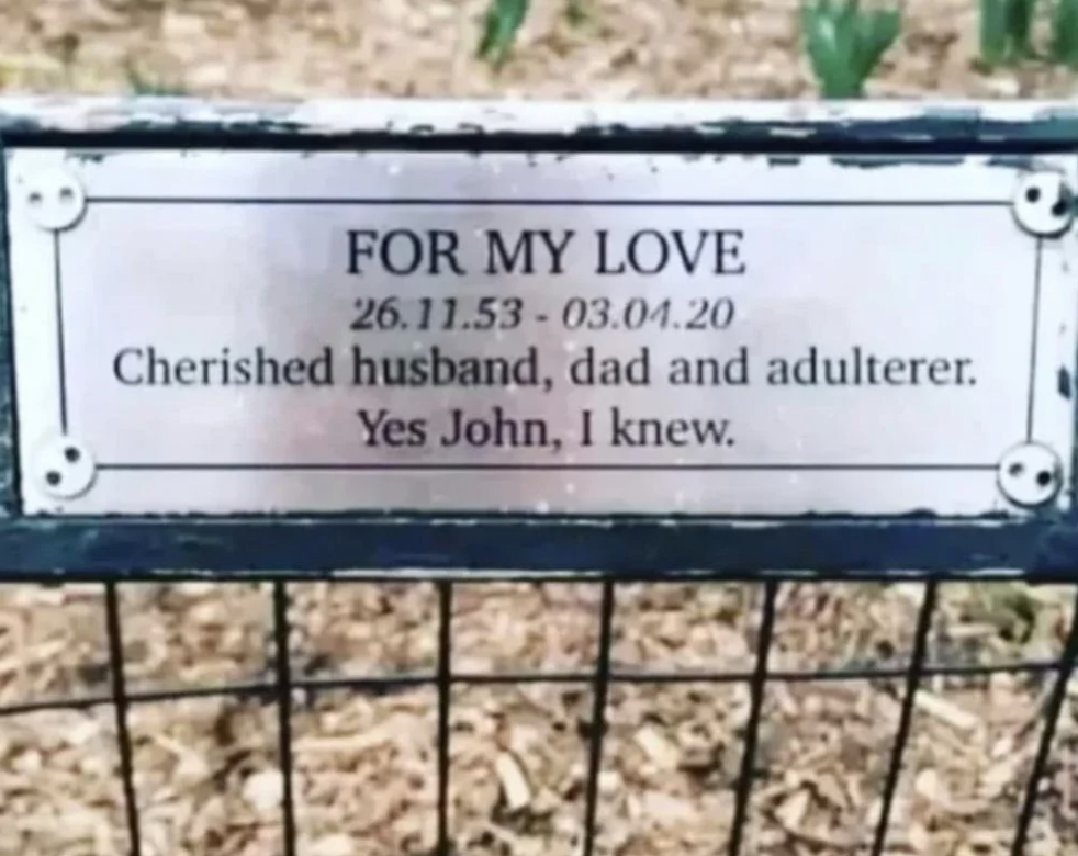 A memorial sign reads, "FOR MY LOVE 26.11.53 - 03.04.20 Cherished husband, dad and adulterer. Yes John, I knew."