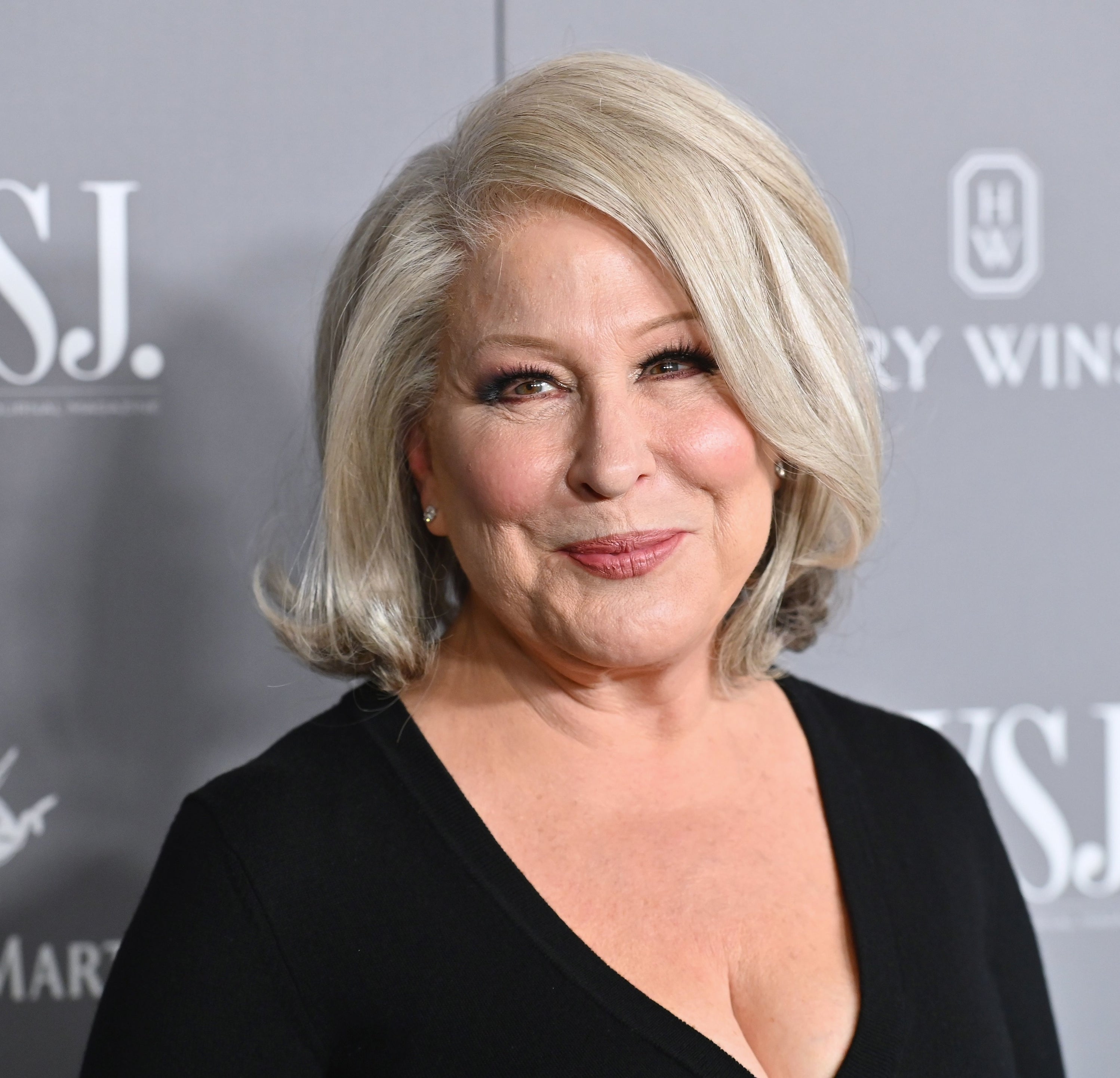 Bette Midler smiles at a Wall Street Journal event in a dark V-neck dress