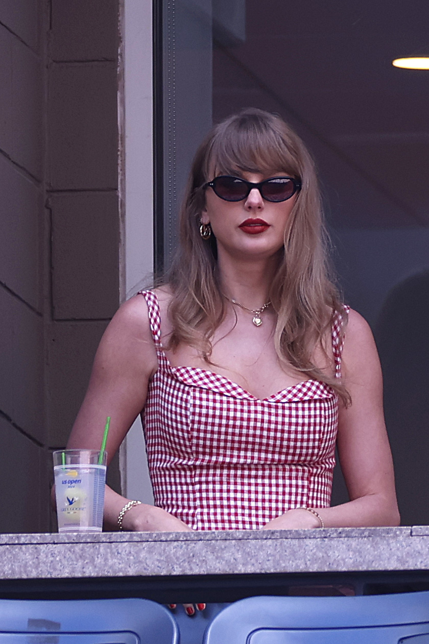 Taylor Swift in a checkered dress, wearing sunglasses, and standing behind a counter with a drink