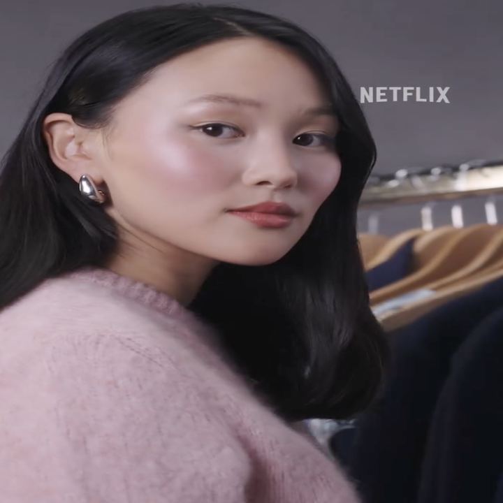 Yerin Ha looking at the camera while touch a suit