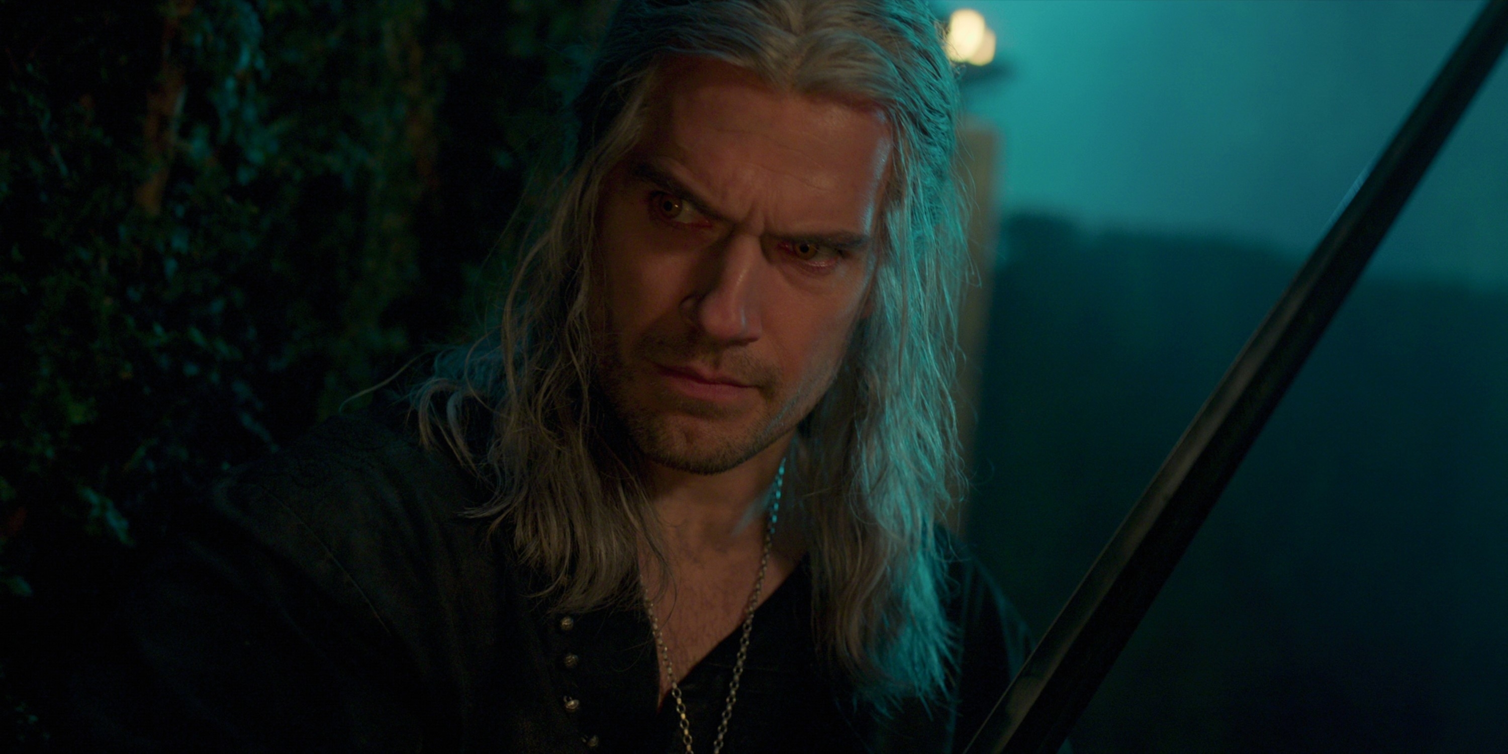 Henry Cavill as Geralt of Rivia in dark medieval attire, holding a sword, with a serious expression from "The Witcher" series