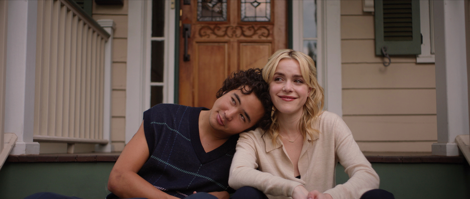 Jared Gilman and Kiernan Shipka sit on porch steps together. Jared leans his head on Kiernan's shoulder, both look content