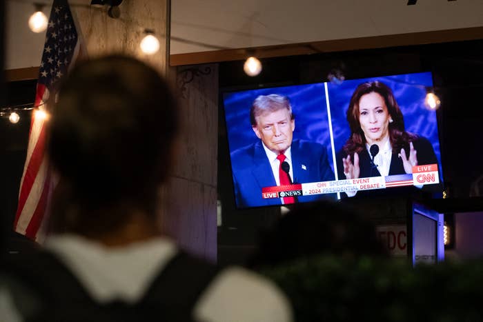 People watching a broadcast of a political debate between Donald Trump and Kamala Harris on CNN