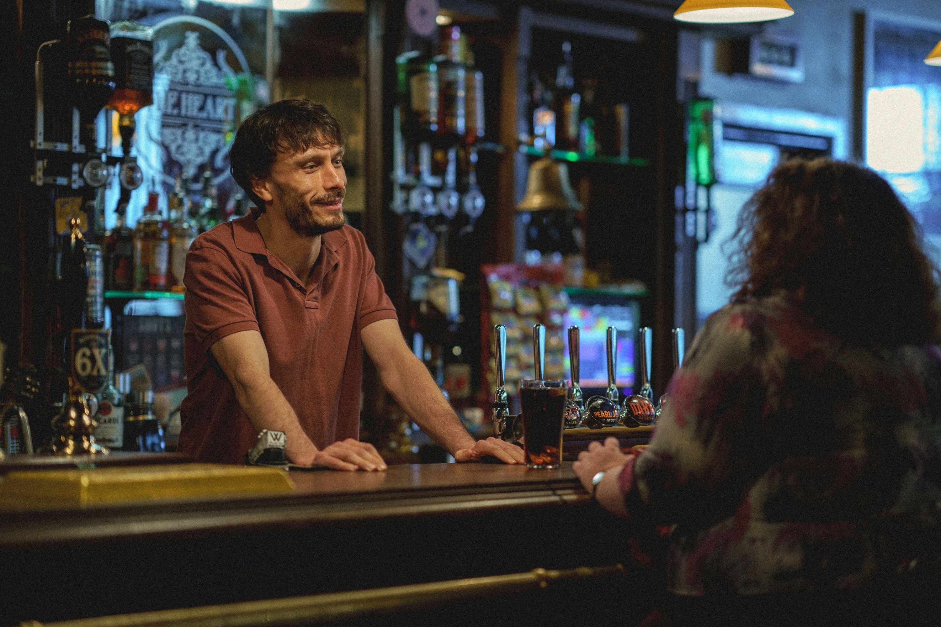 Richard Gadd interacts with a patron at a bar in a likely scene from Baby Reindeer