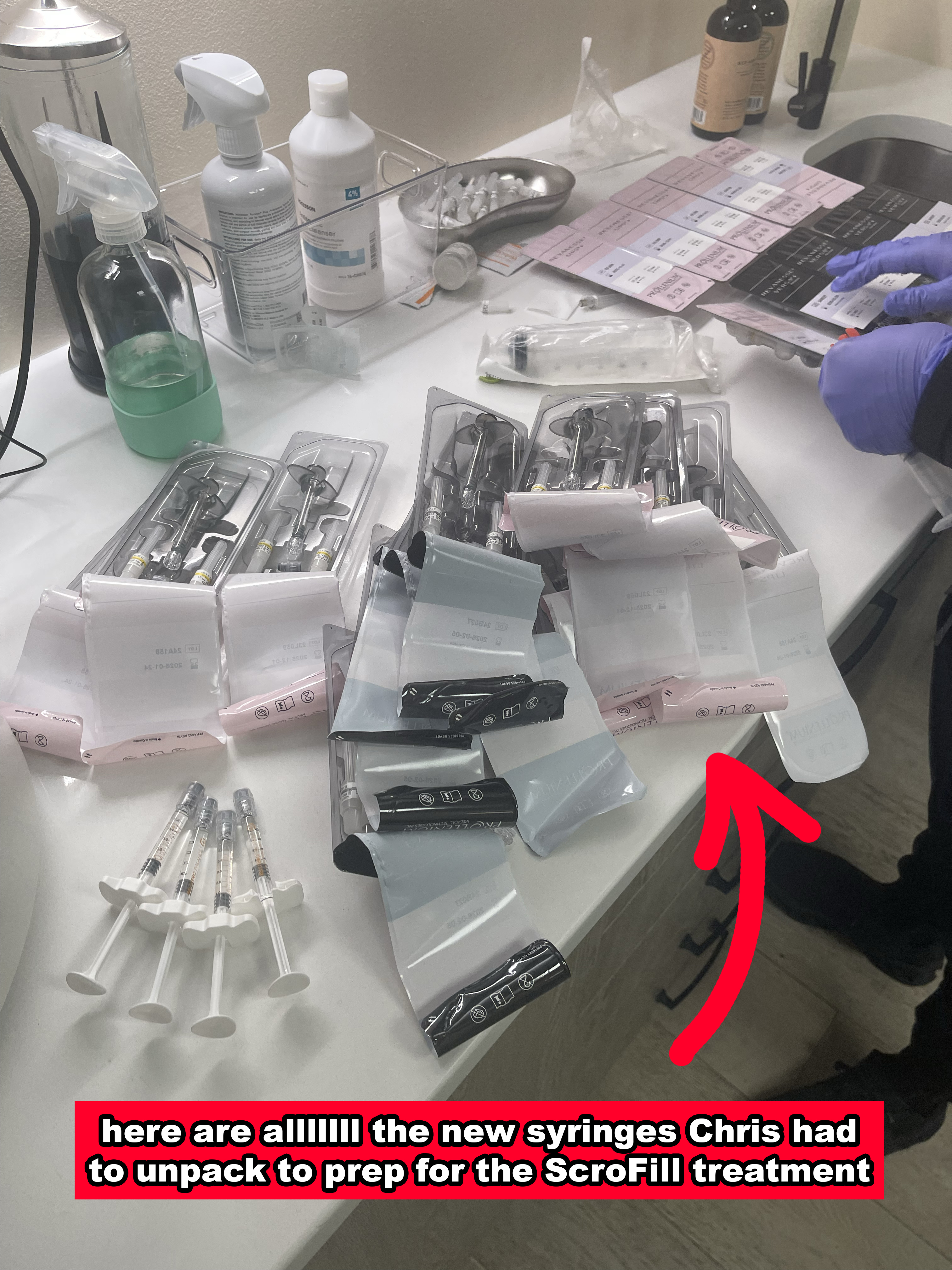 A variety of syringes and medical supplies are laid out on a counter